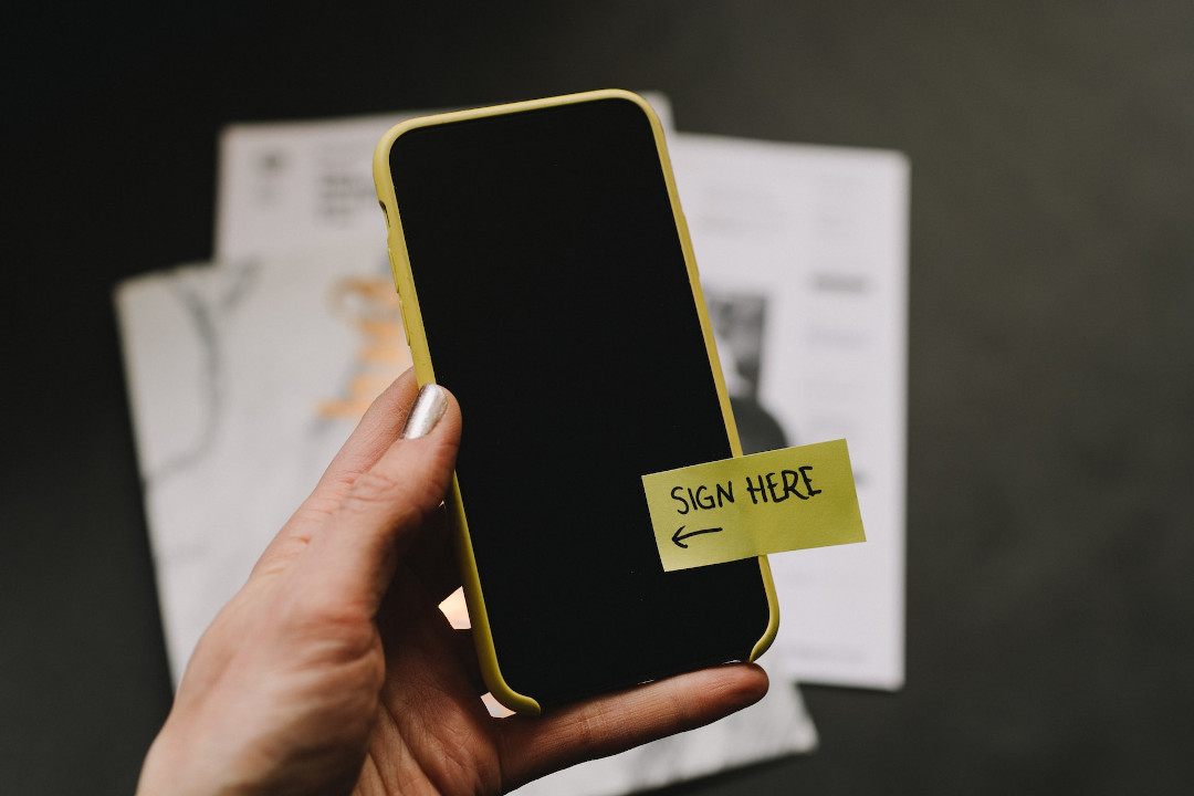 Person holding smartphone with label on screen